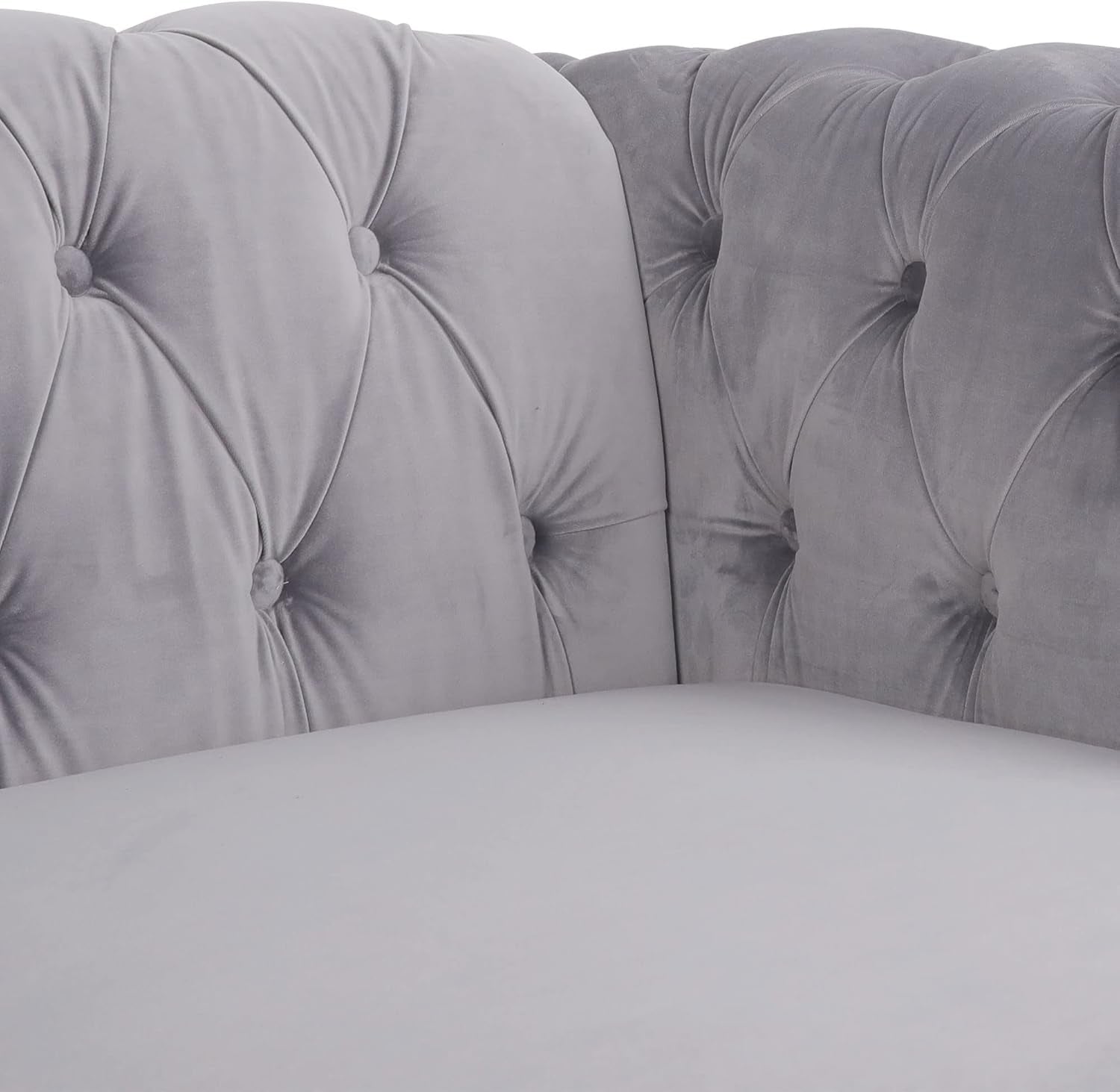 Gray tufted headboard with matching bedding on a bed.