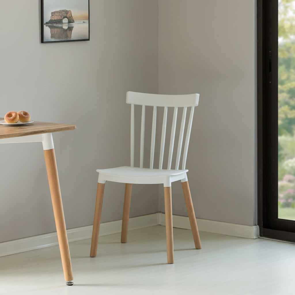 White chair with wooden legs against a green wall
