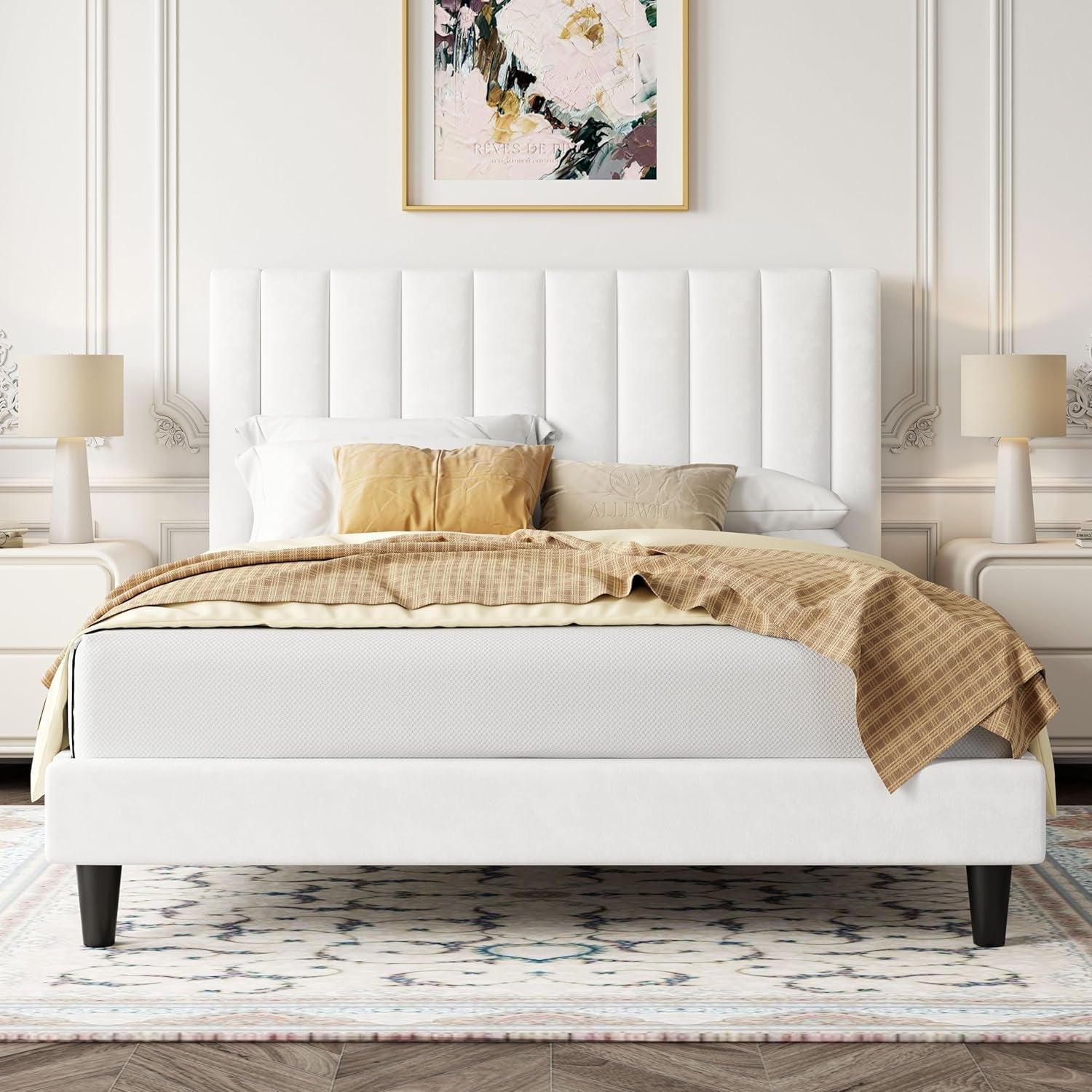 White upholstered bed with gold bedding in a stylish bedroom setting.