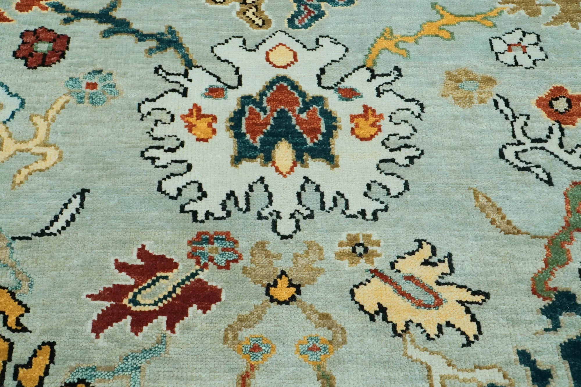 Close-up of a patterned rug with floral designs on a light blue background
