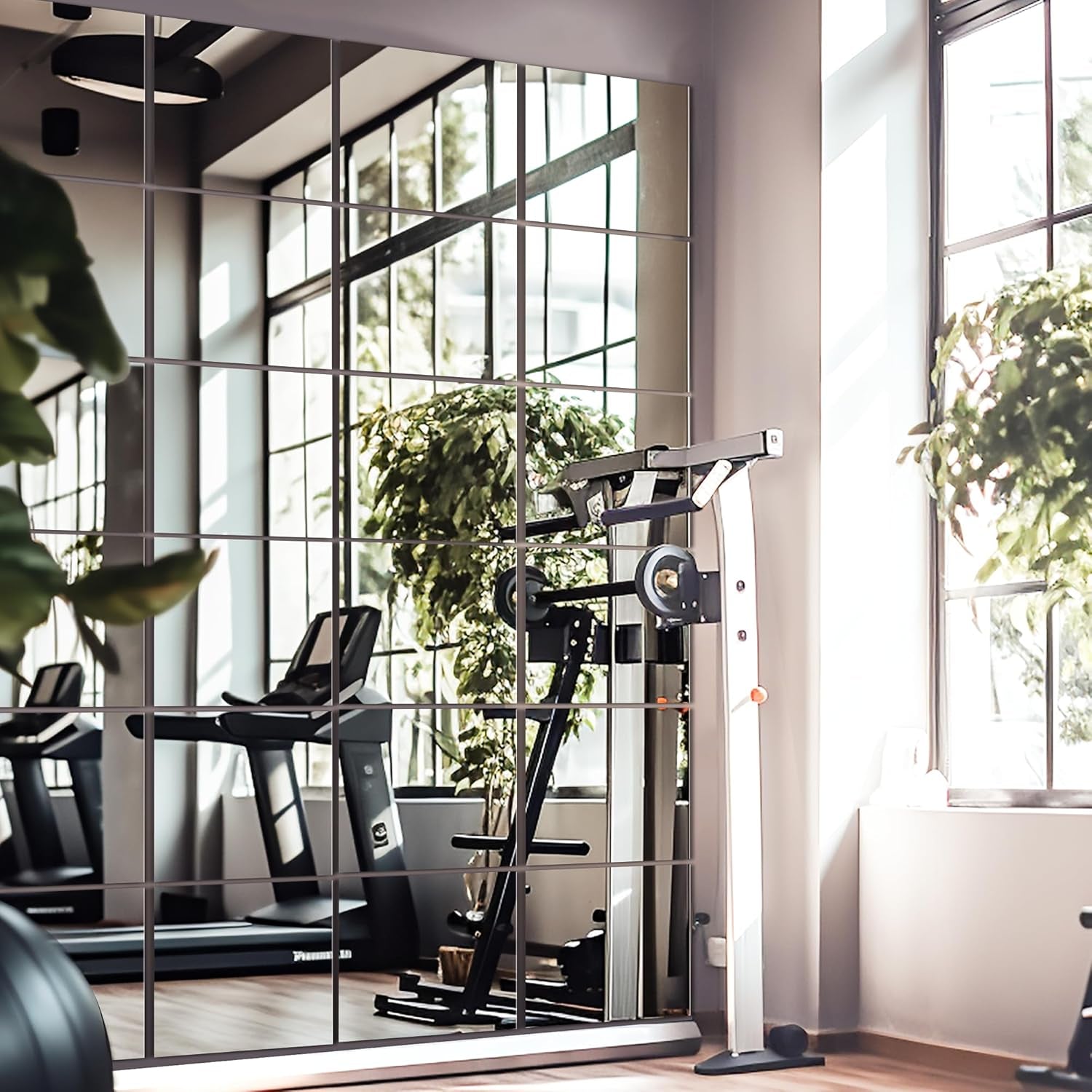 Modern gym interior with exercise equipment and large windows.