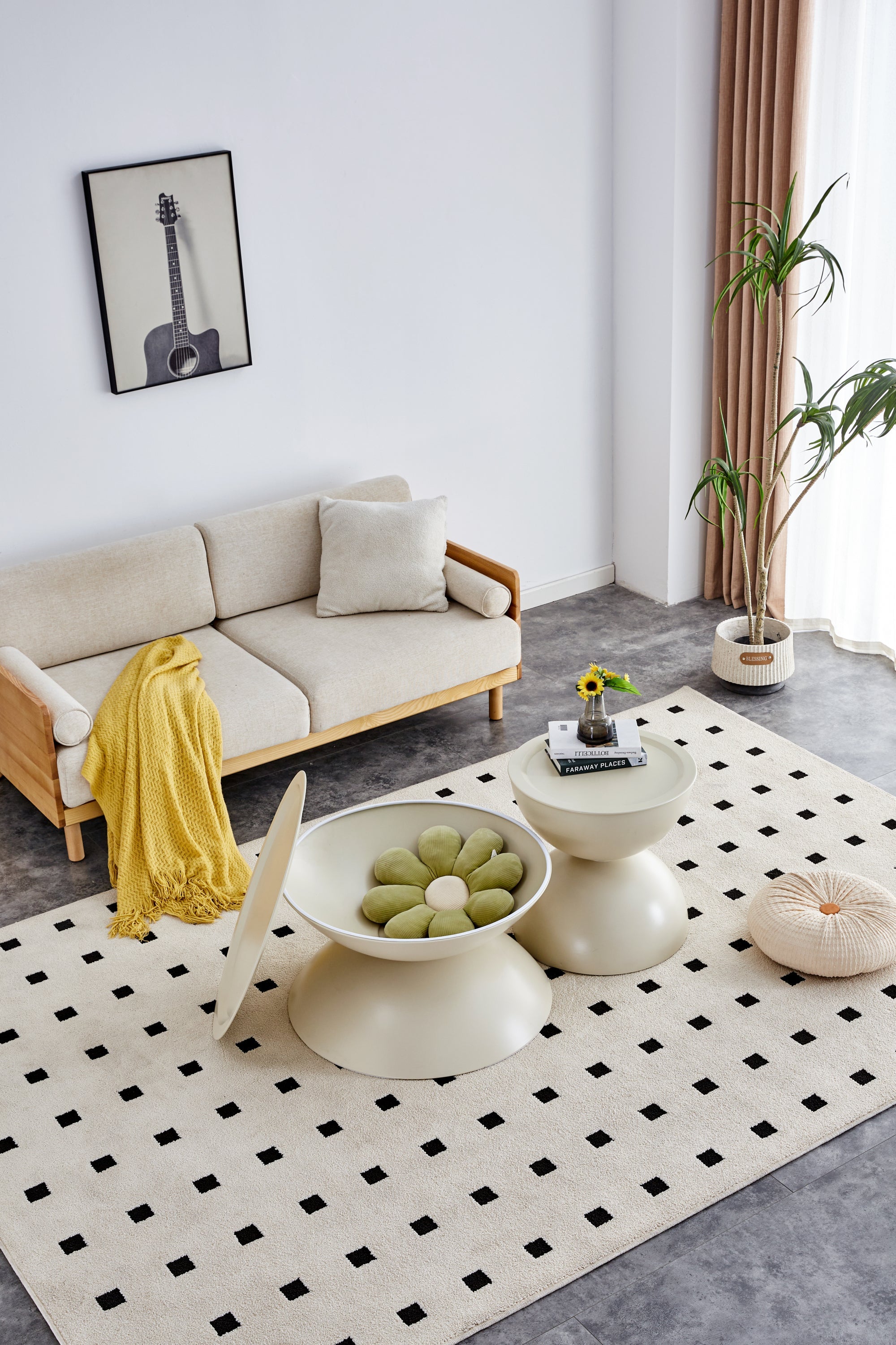 Modern living room with a beige sofa, white rug, and decorative items.