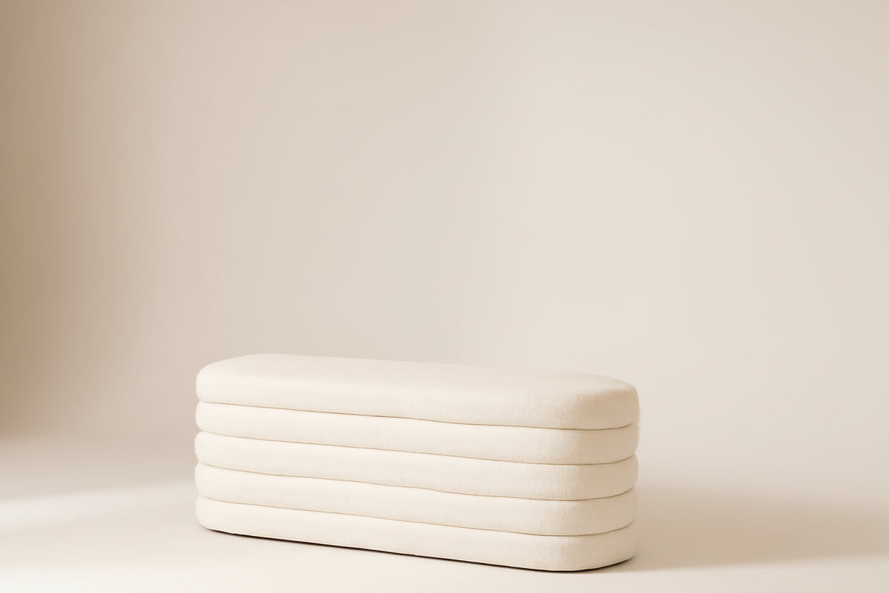 White inflatable mattress against a beige wall with a small table and decorative items.