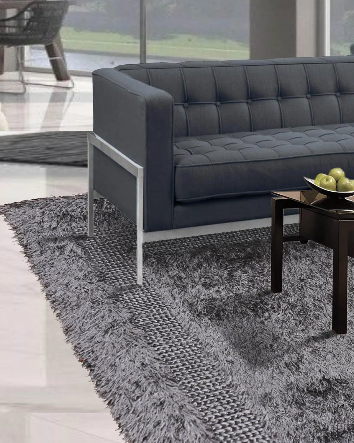 Gray tufted sofa in a modern living room with a gray rug.