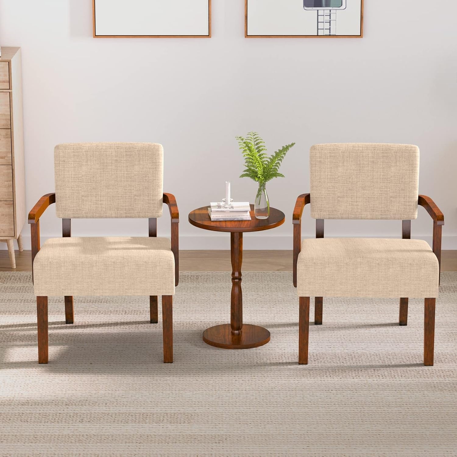 Two beige chairs with wooden legs around a small round table in a room.
