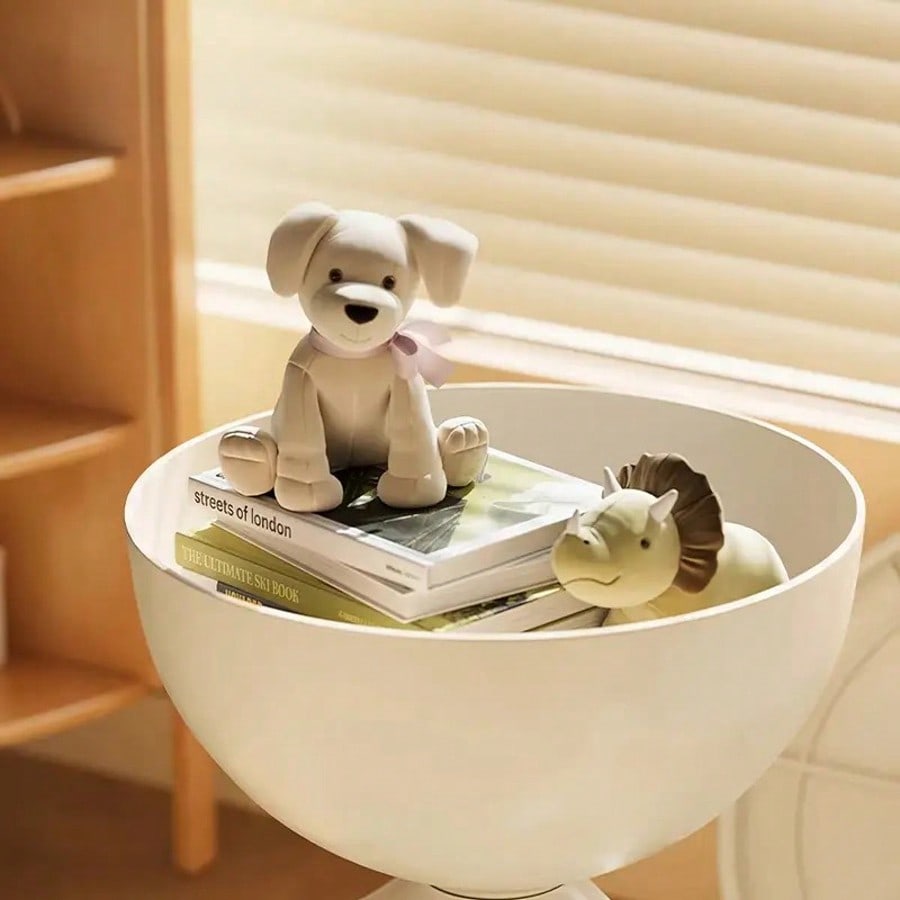 Small dog figurine on books inside a white bowl with a blurred background