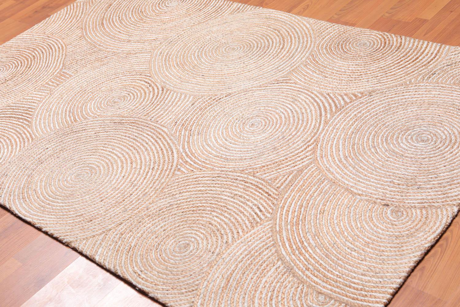 Beige woven area rug on a wooden floor