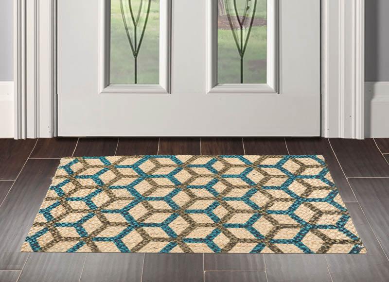 Patterned doormat on a wooden floor in front of a glass door.