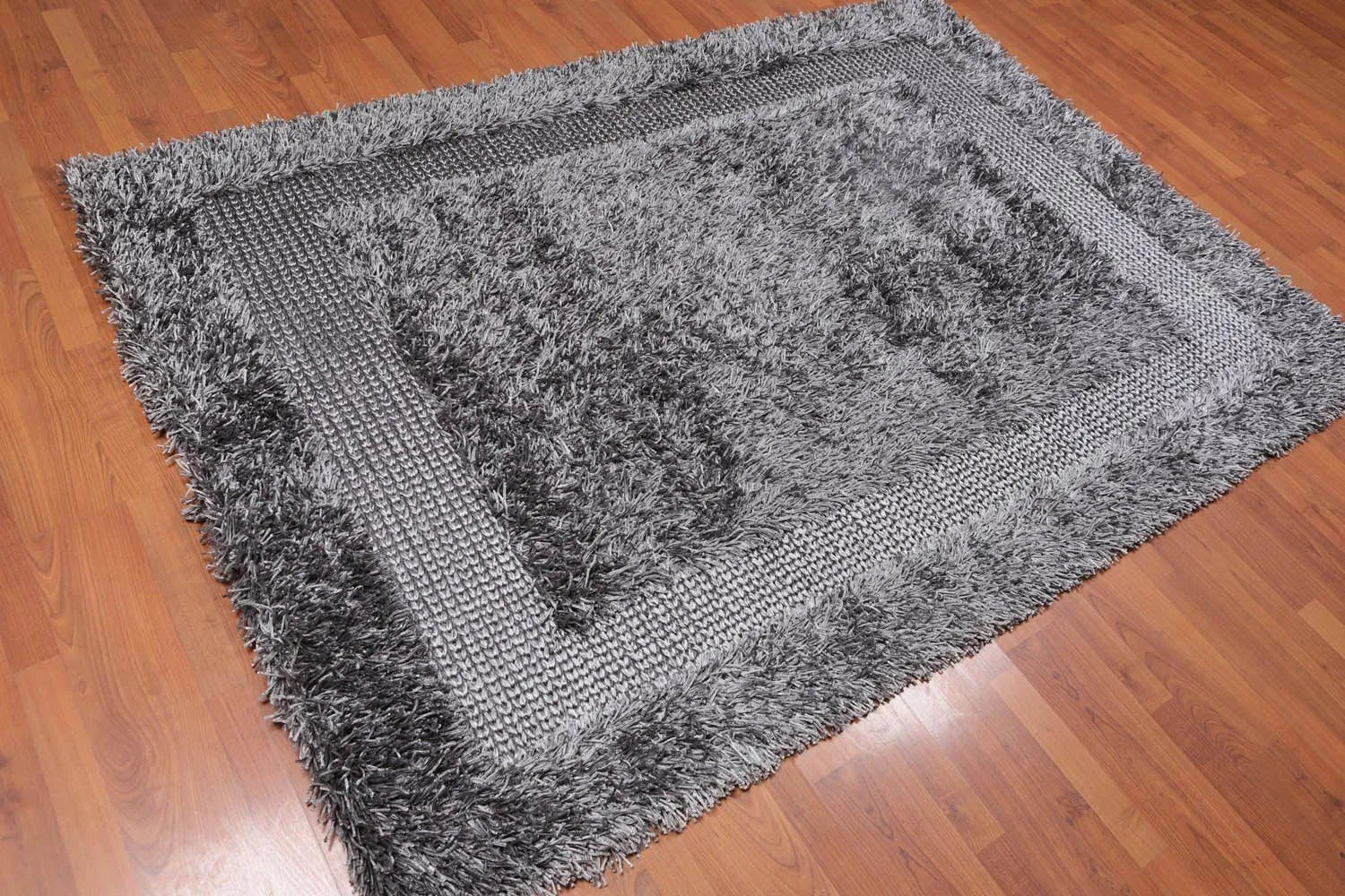 Gray tufted sofa in a modern living room with a gray rug.