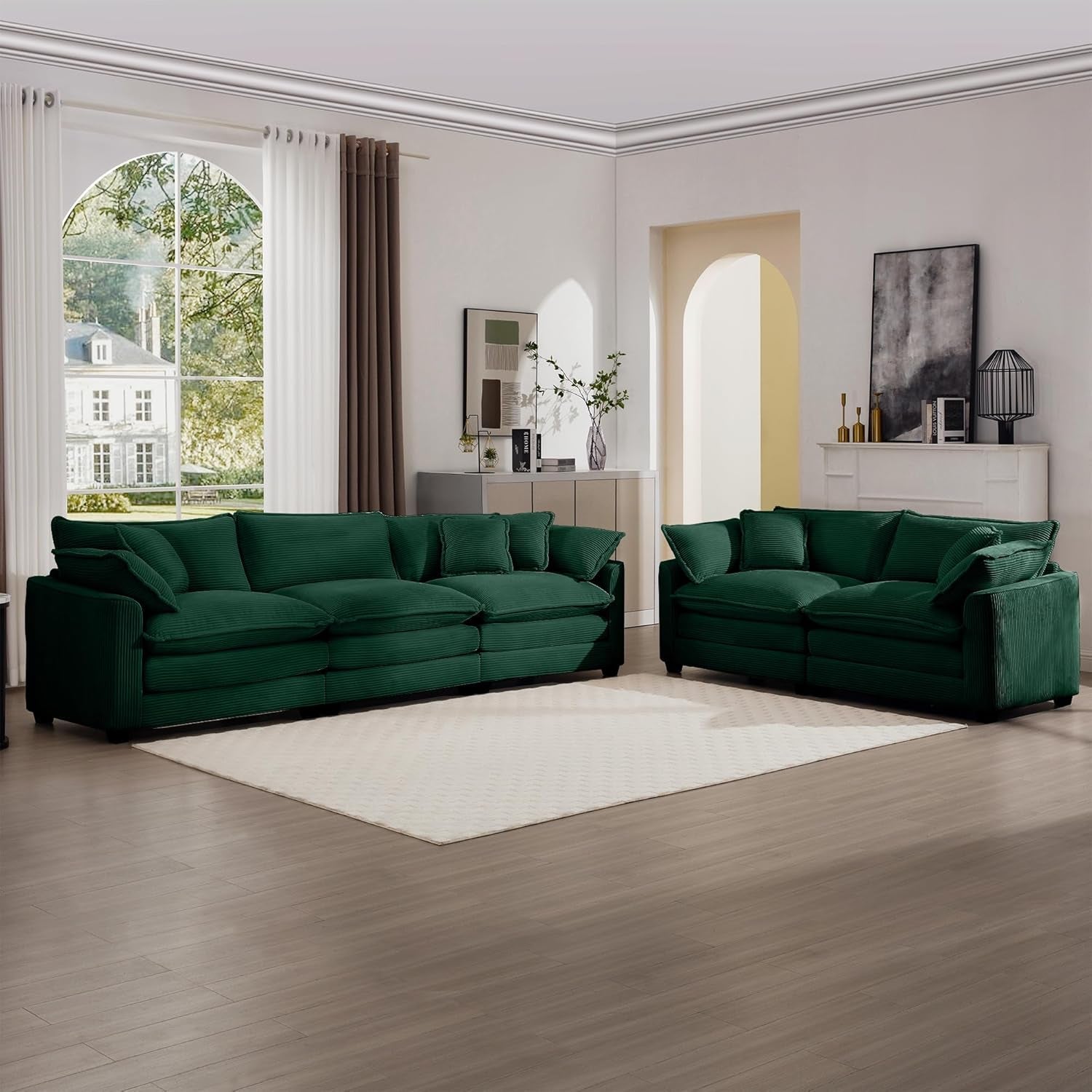 Green sectional sofa in a modern living room with large windows.