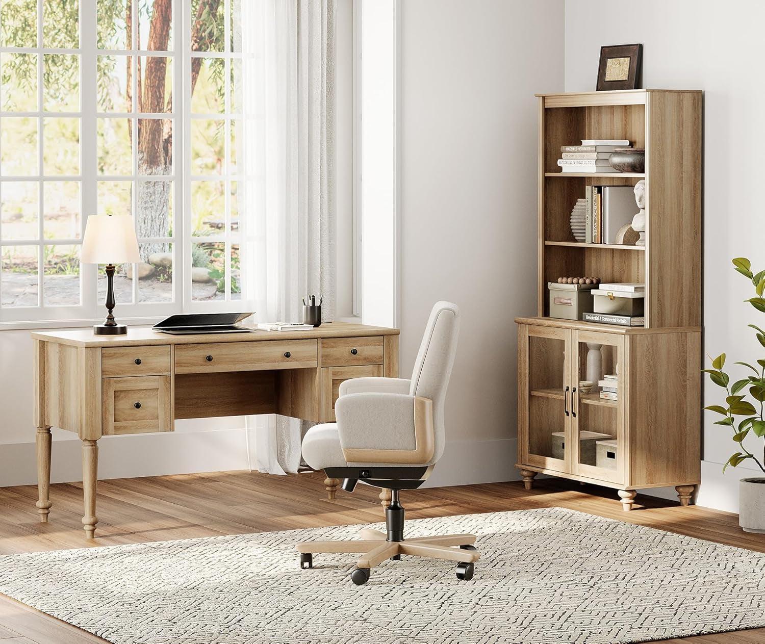 Home office with wooden desk, chair, and bookshelf in a bright room.