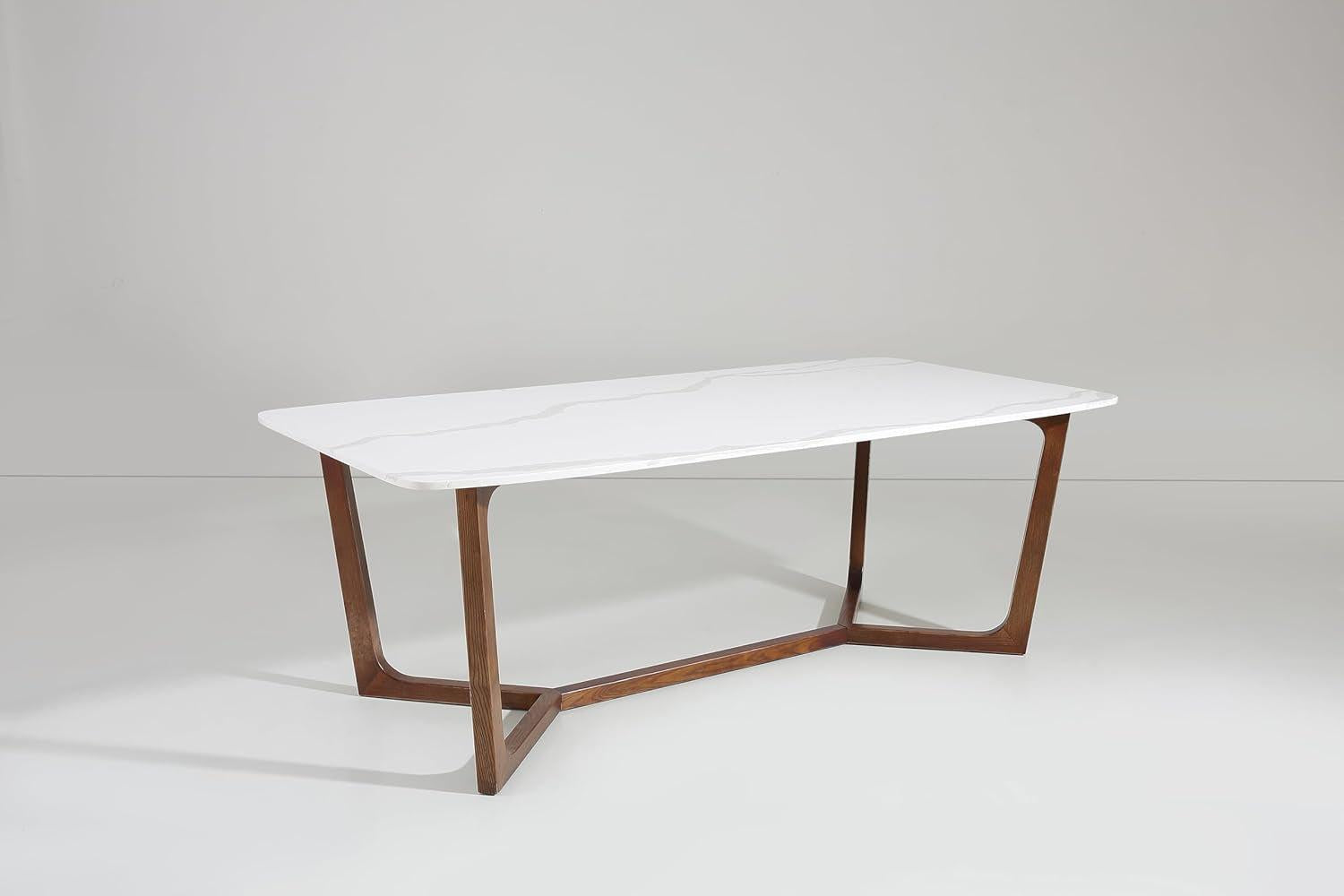 Modern dining table with white top and wooden legs on a plain background