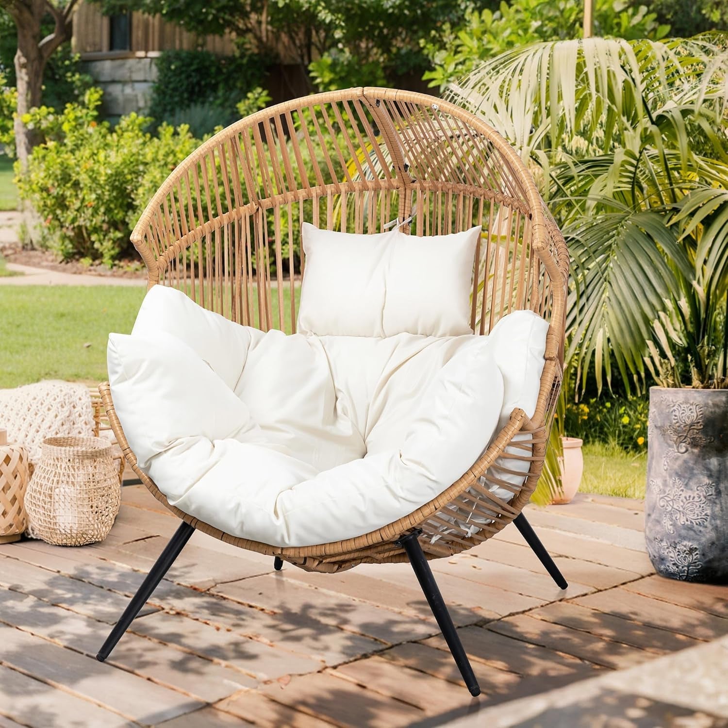 Wicker chair with white cushions on a wooden deck surrounded by greenery