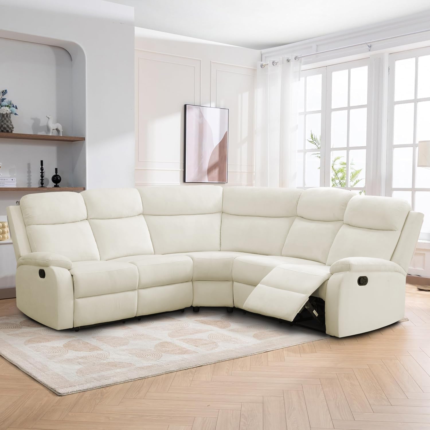 White sectional sofa in a living room with large windows and minimal decor.