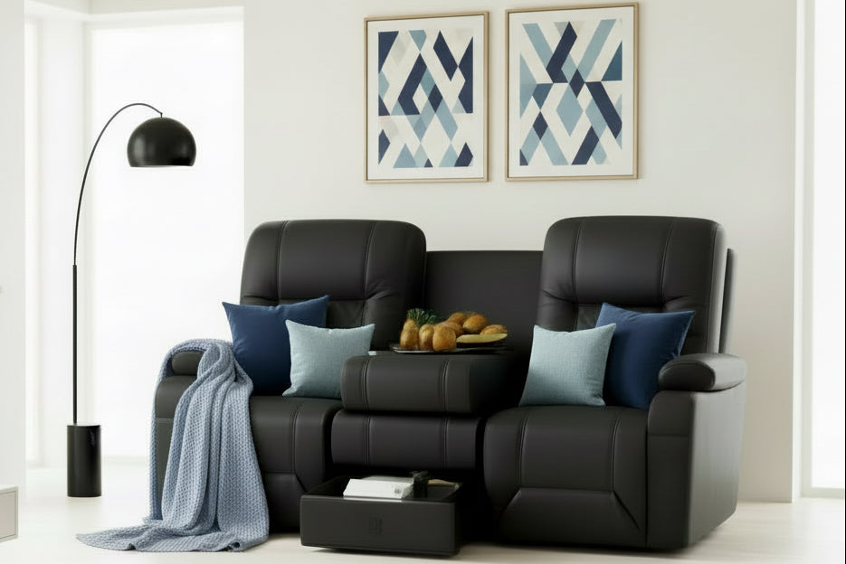 Black leather recliner chairs in a living room setting with a tray of snacks on a small table.