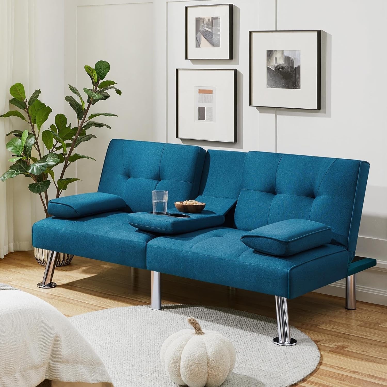 Blue sofa in a living room with a plant and pumpkin decoration.