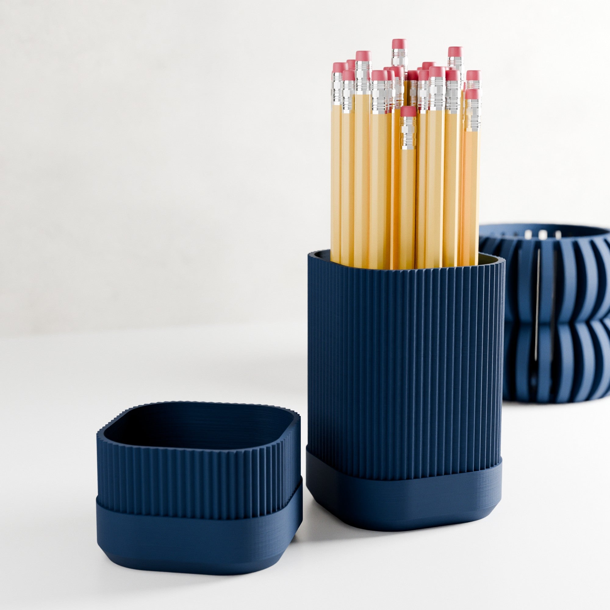 Navy blue ribbed pencil holder with pencils on a white background