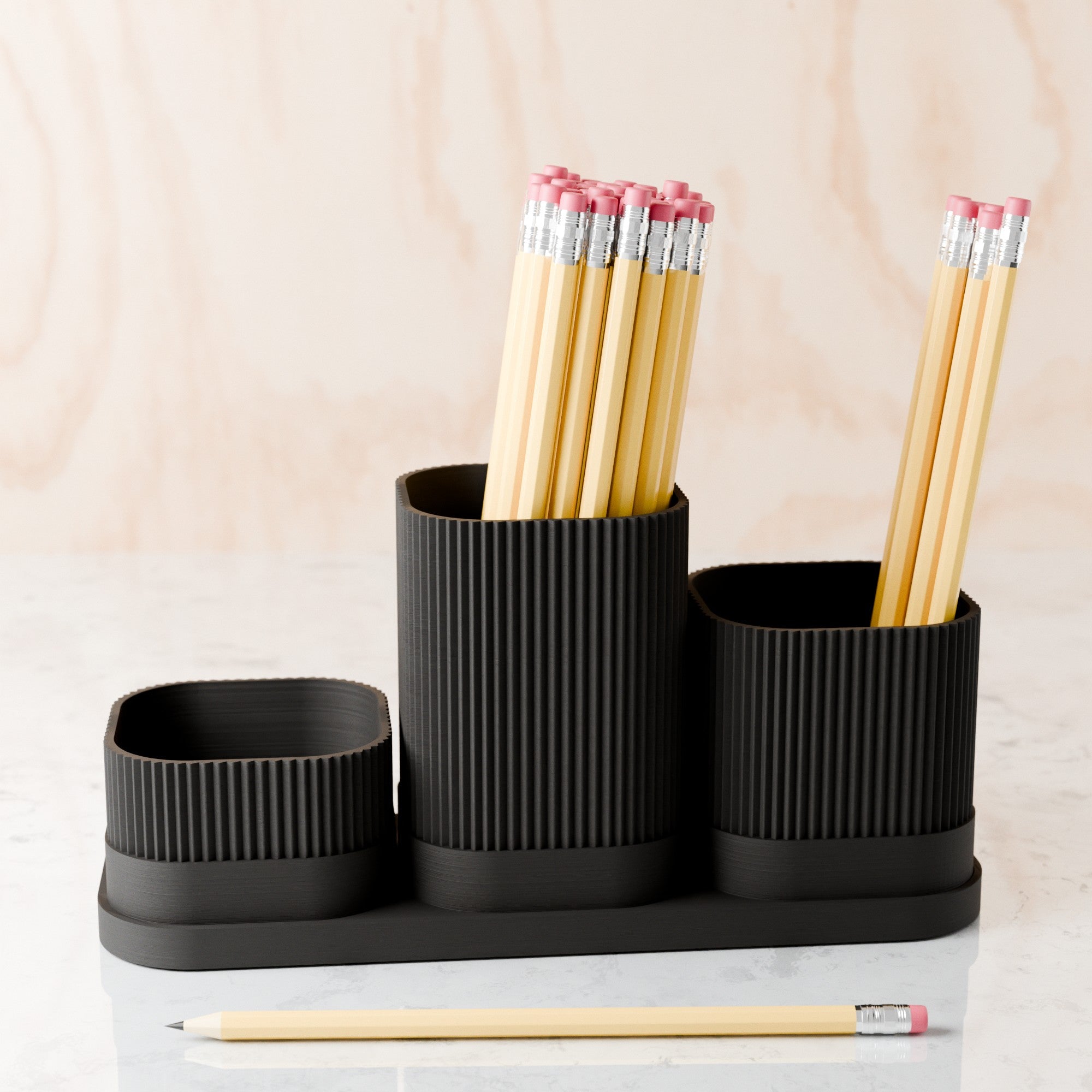 Black desk organizer with pencils on a light background