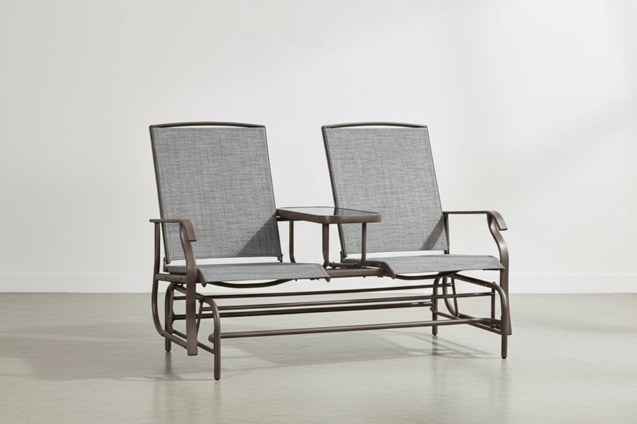 Two gray cushioned glider chairs with a small table on a white background