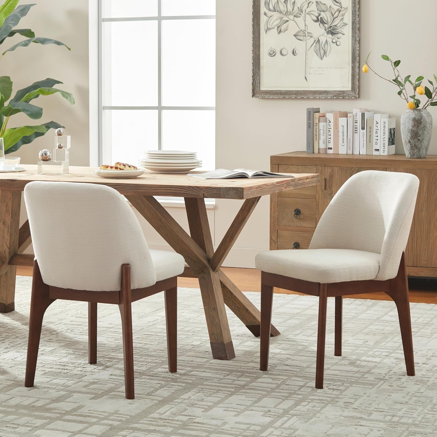 Dining room with wooden table and white chairs, books, and decor items.