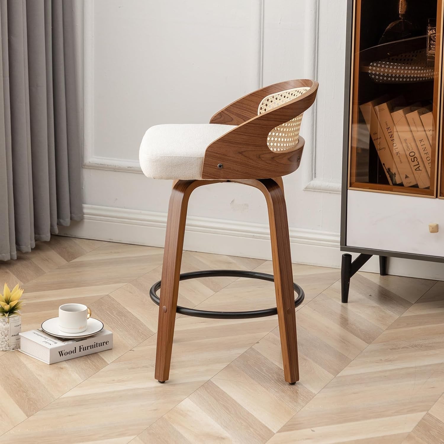 Wooden bar stool with white cushion on a wooden floor in a room with a cabinet and books.