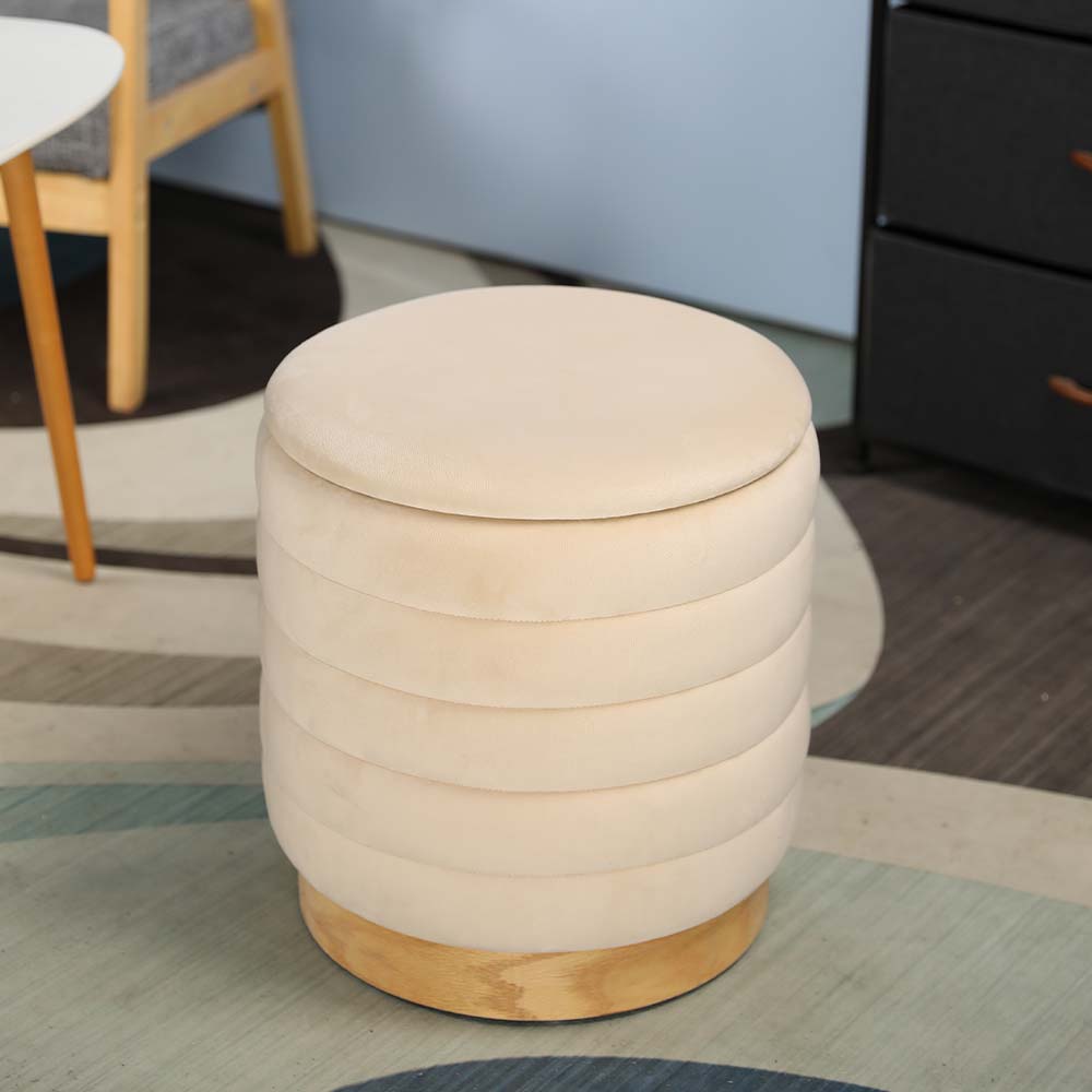 Round beige ottoman with wooden base on a patterned rug