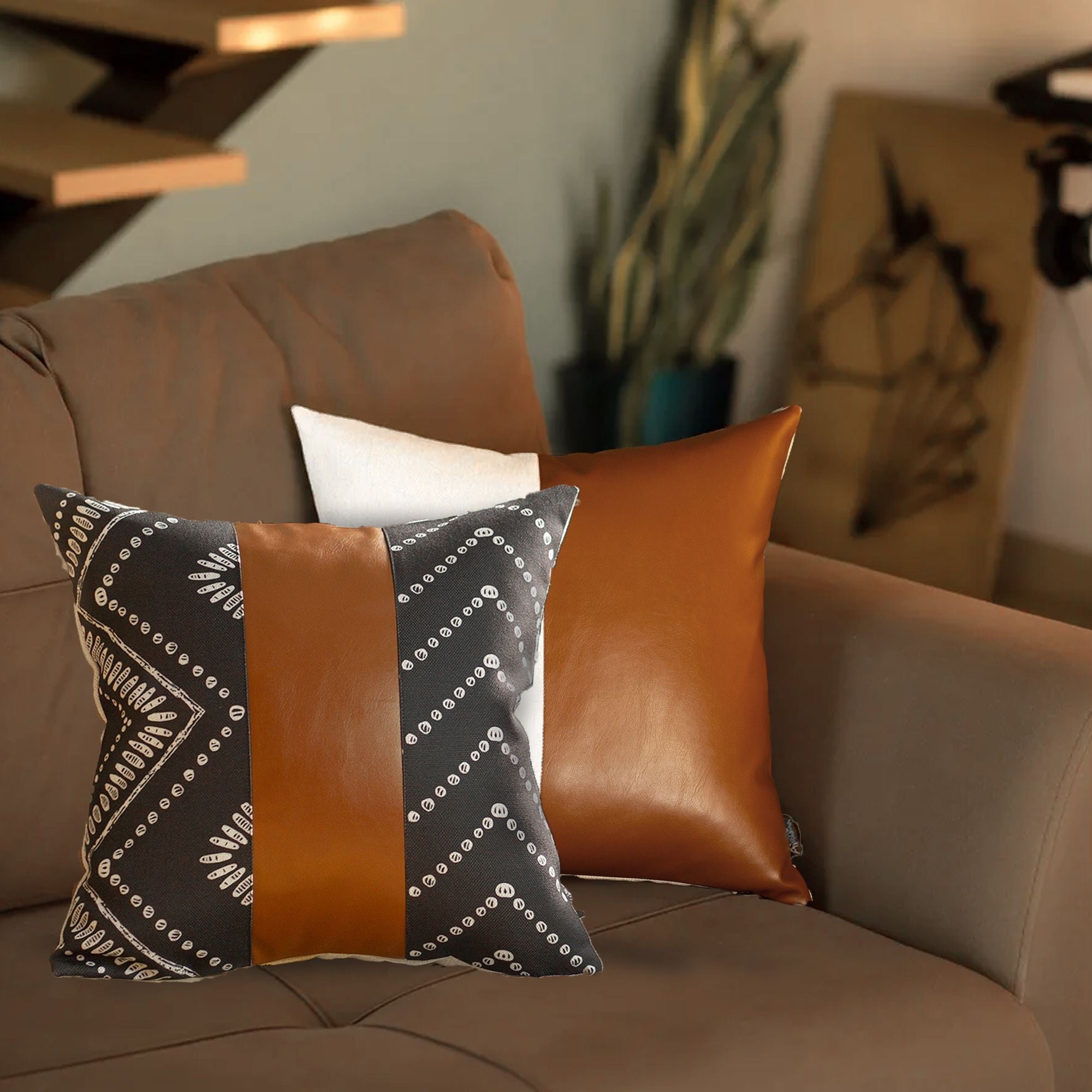 Decorative pillows on a brown sofa with a blurred indoor background