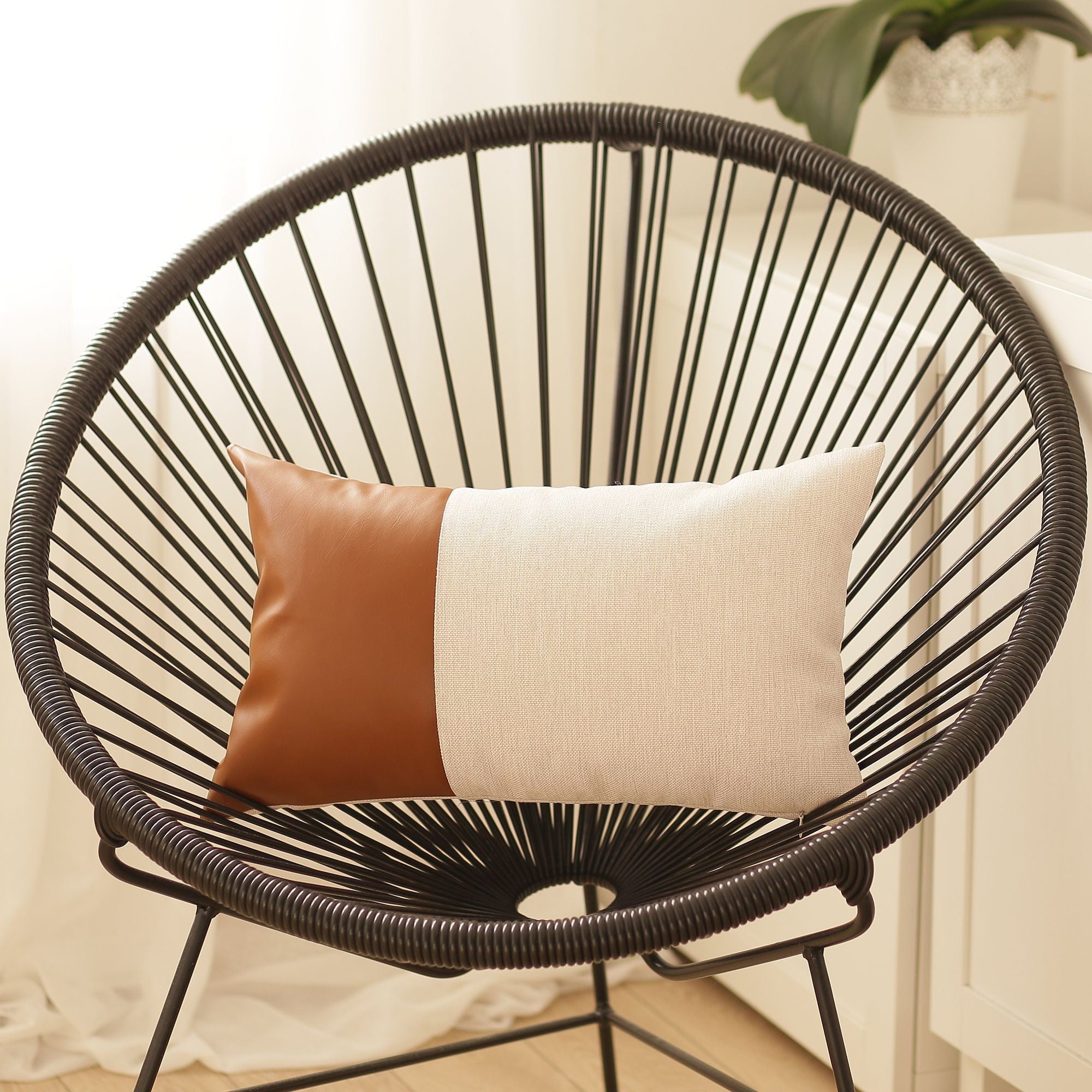 Wicker chair with two pillows on a blurred background