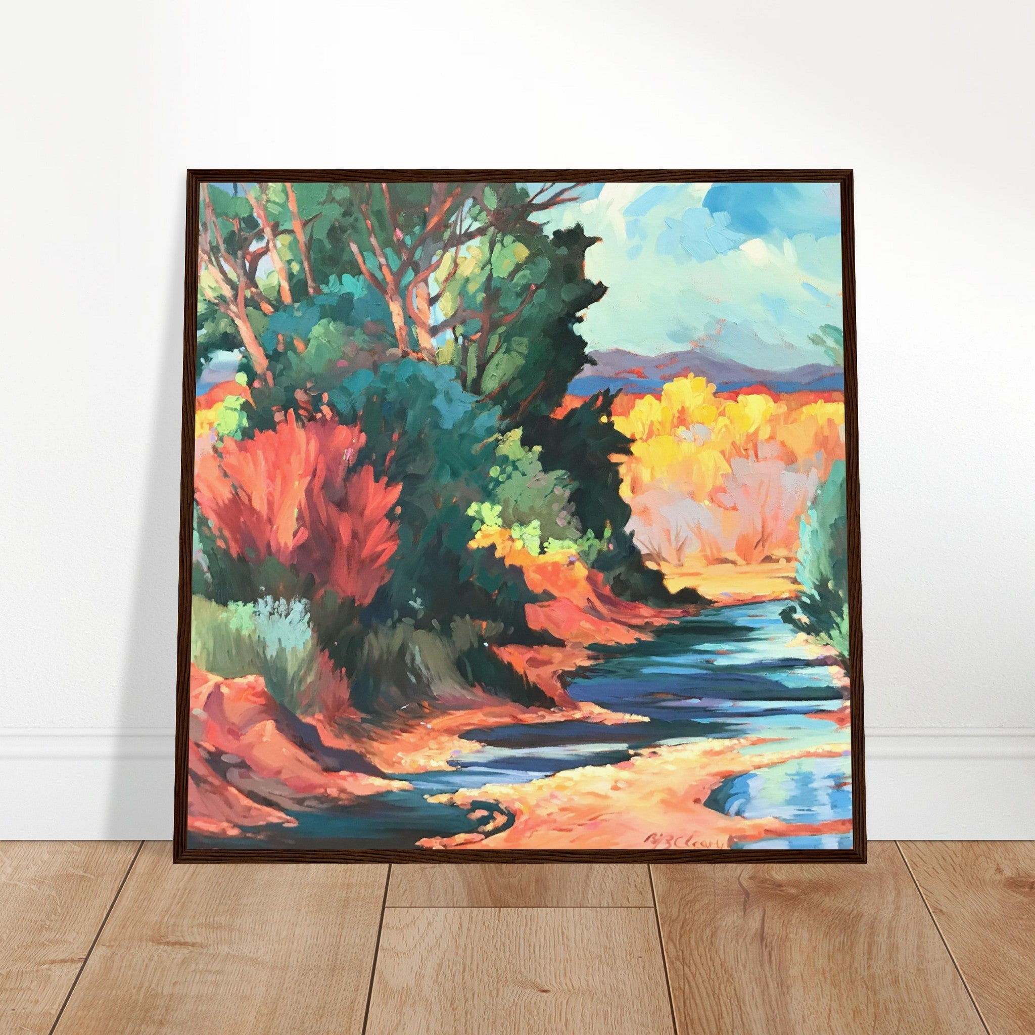 Framed colorful landscape painting on a white wall