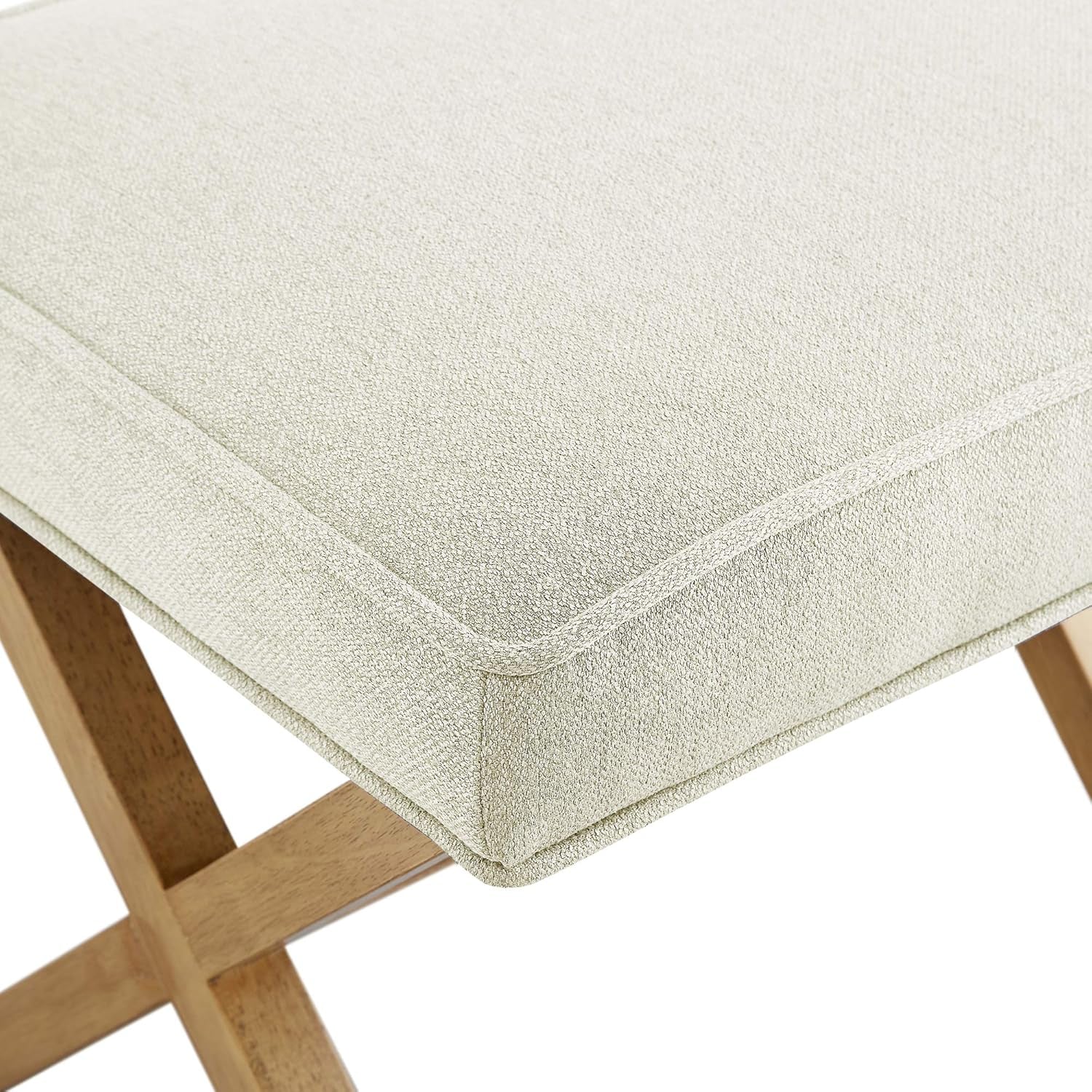 Beige cushioned stool with wooden legs on a white background