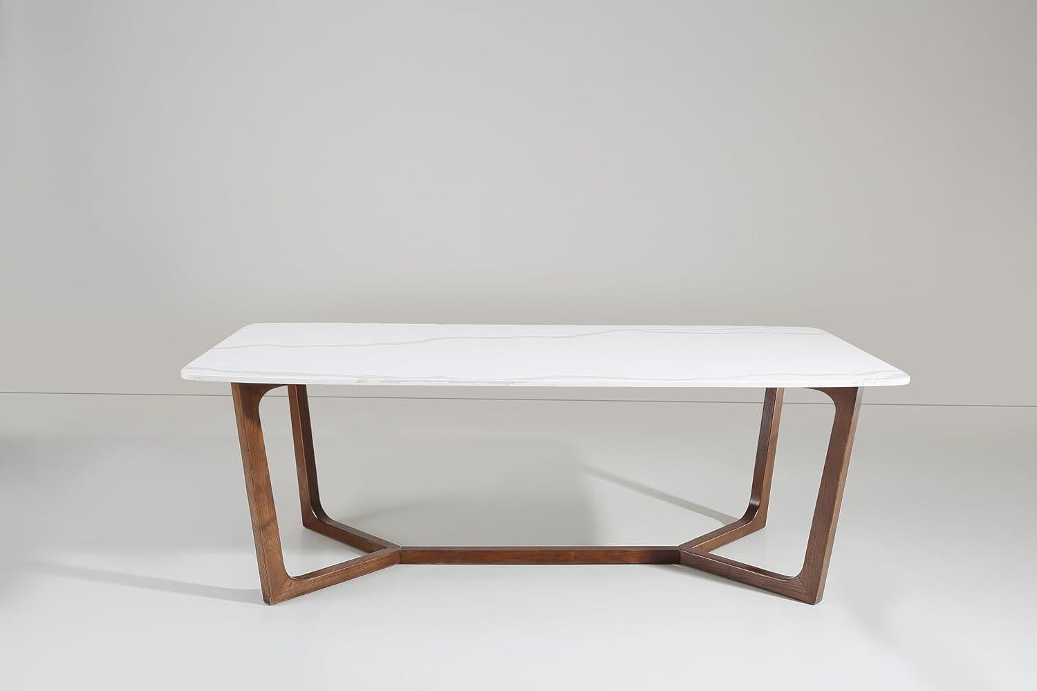 Modern table with white top and wooden base on a plain background