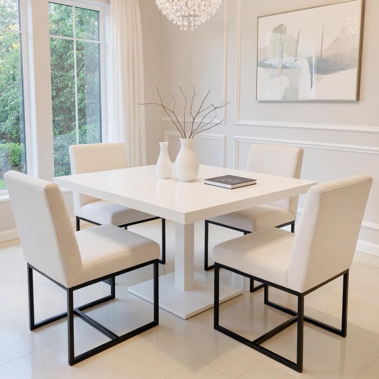 Modern dining room with a white table and chairs, featuring a chandelier and large windows.