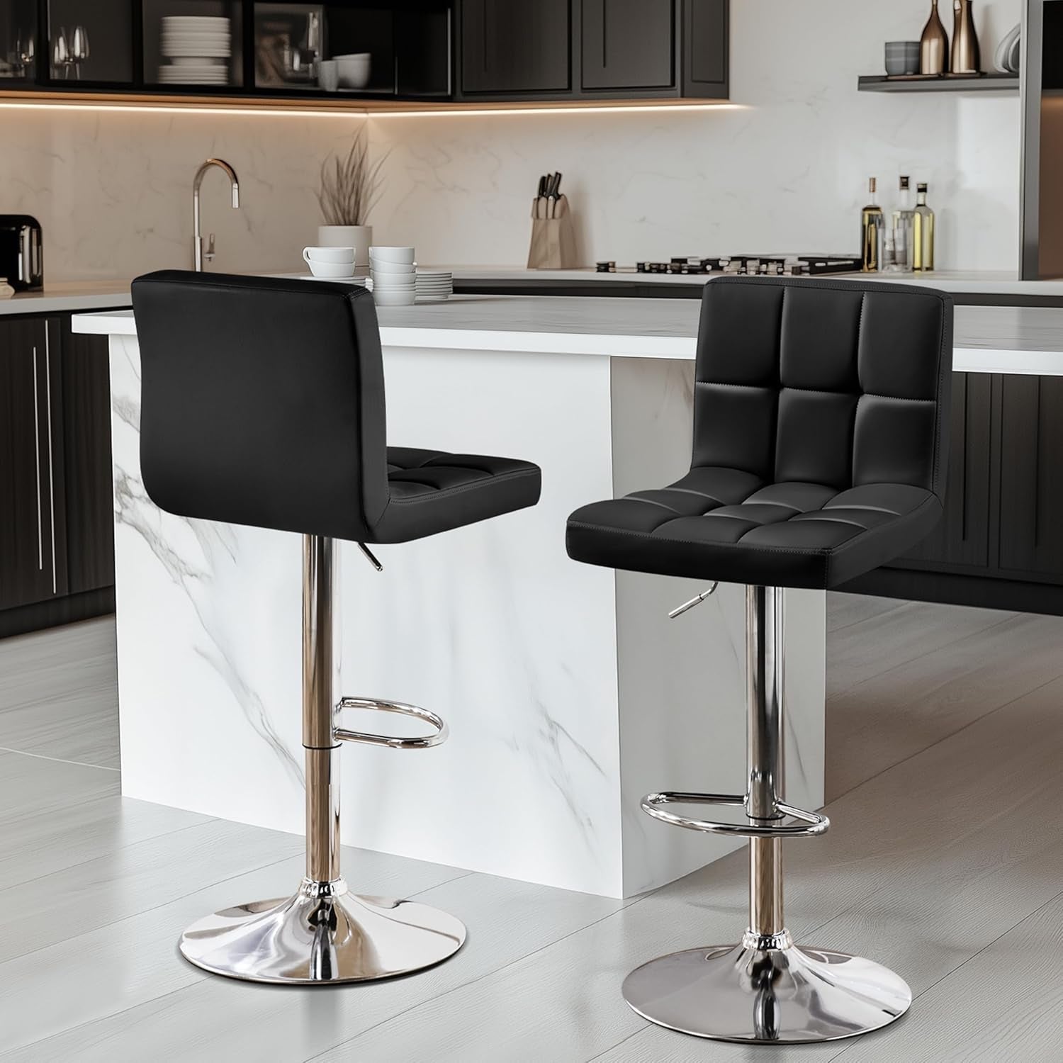 Modern kitchen with black bar stools and a white marble island.