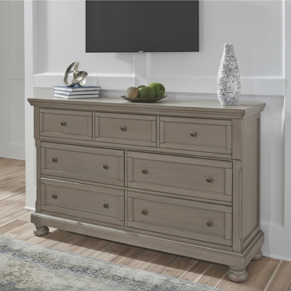 Wooden dresser with multiple drawers on a wooden floor.