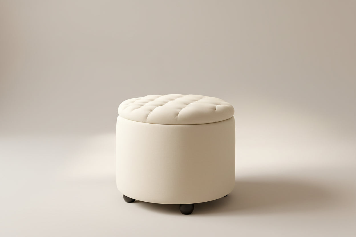 Round beige ottoman with tufted lid in a room with a wooden cabinet and decorative vase.