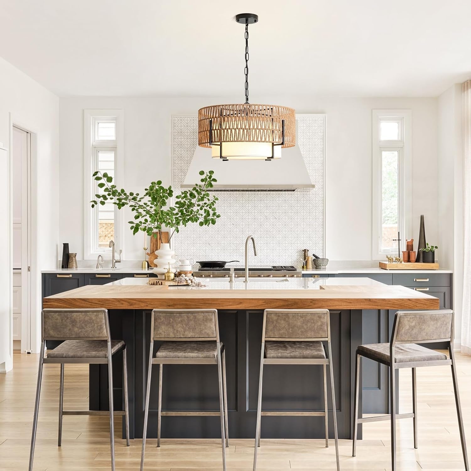 Modern kitchen with a wooden island and stools, featuring a pendant light and white cabinets.