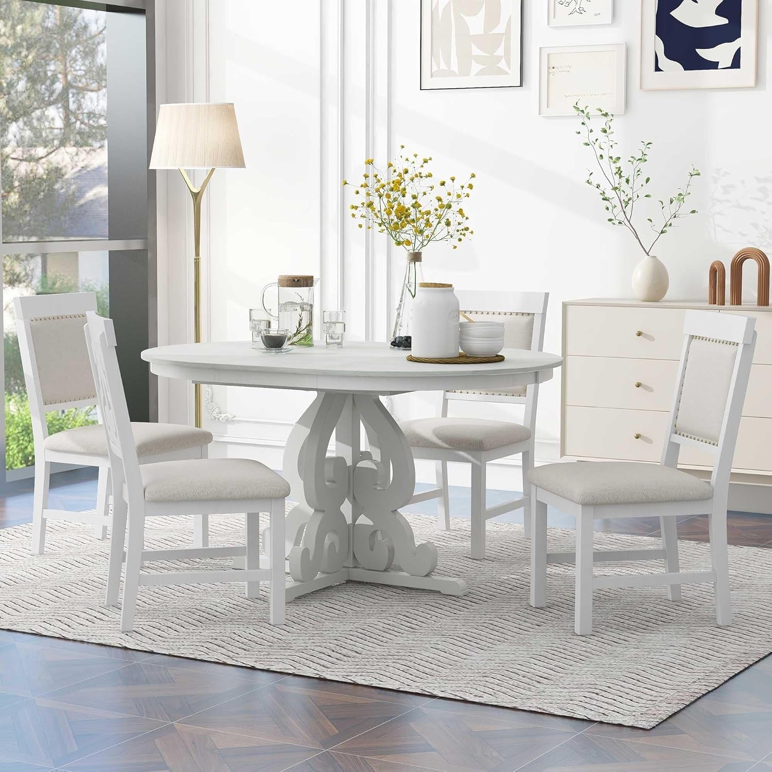 Dining room with a white round table and chairs on a rug.