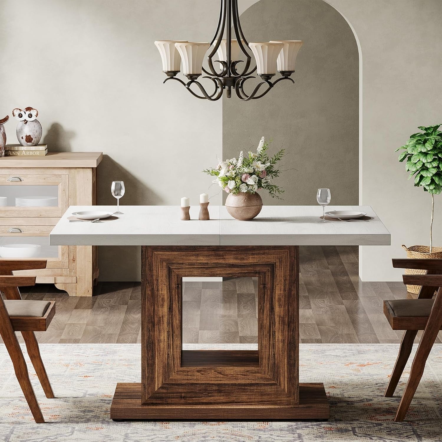 Dining room with a wooden table and marble countertop, chandelier, and decor items.