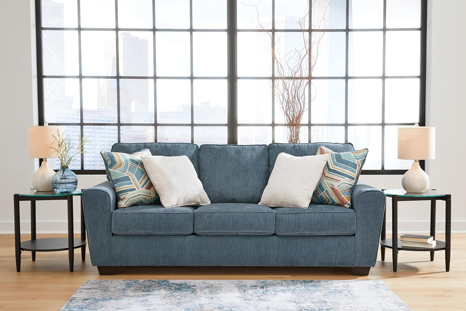 Blue sofa with decorative pillows in a living room setting