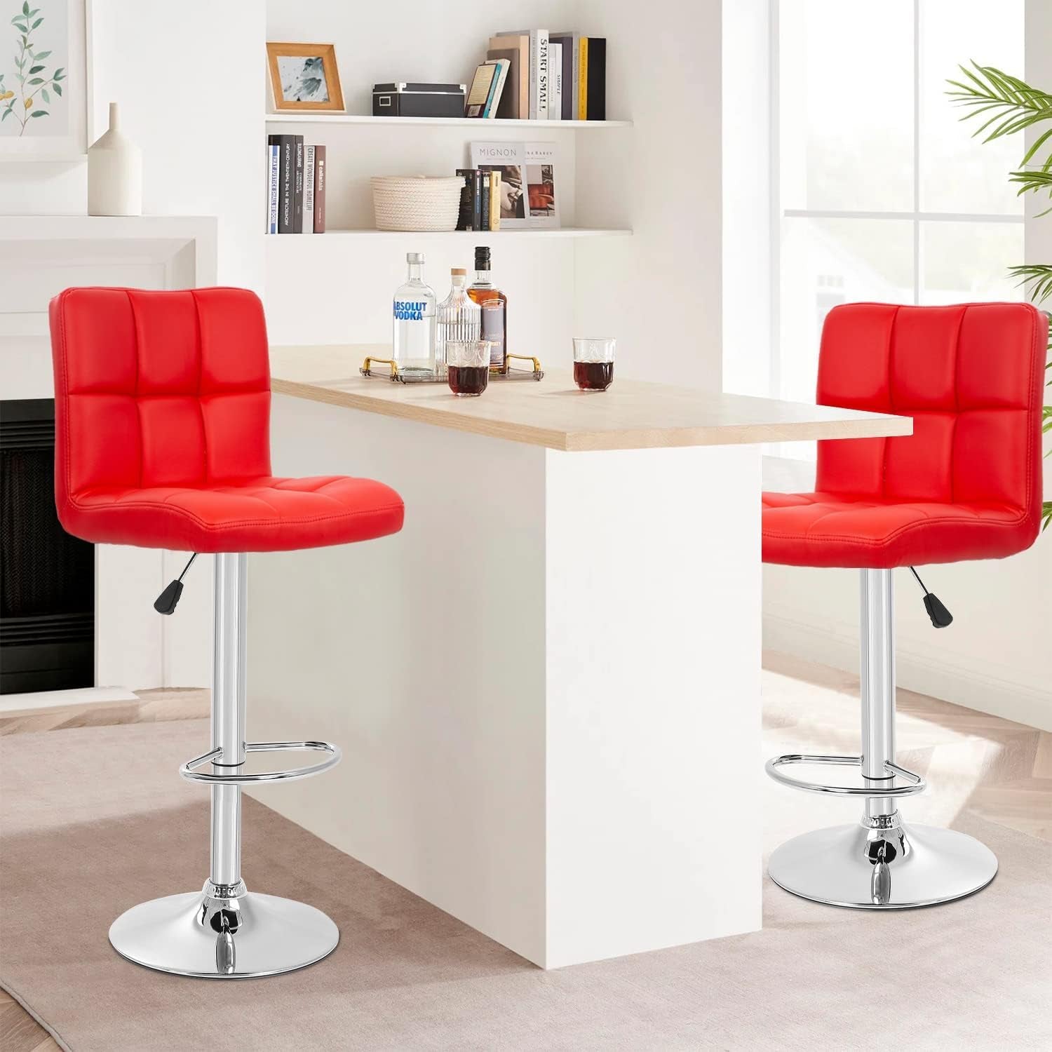 Two red bar stools in front of a small table with drinks in a home setting.