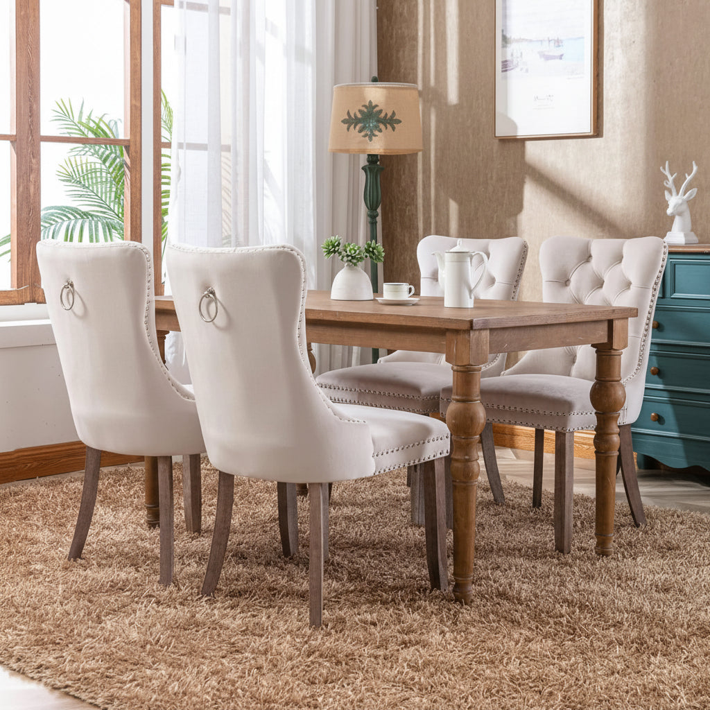 Dining room with wooden table and Nikki Collection dining chairs with wood legs and nailhead trim.