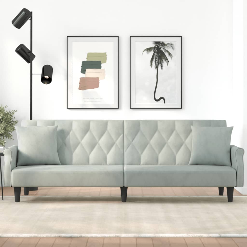 Light gray sofa in a living room with wall art and a lamp.