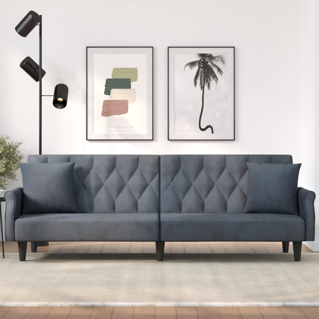 Gray tufted sofa in a living room with wall art and a floor lamp.