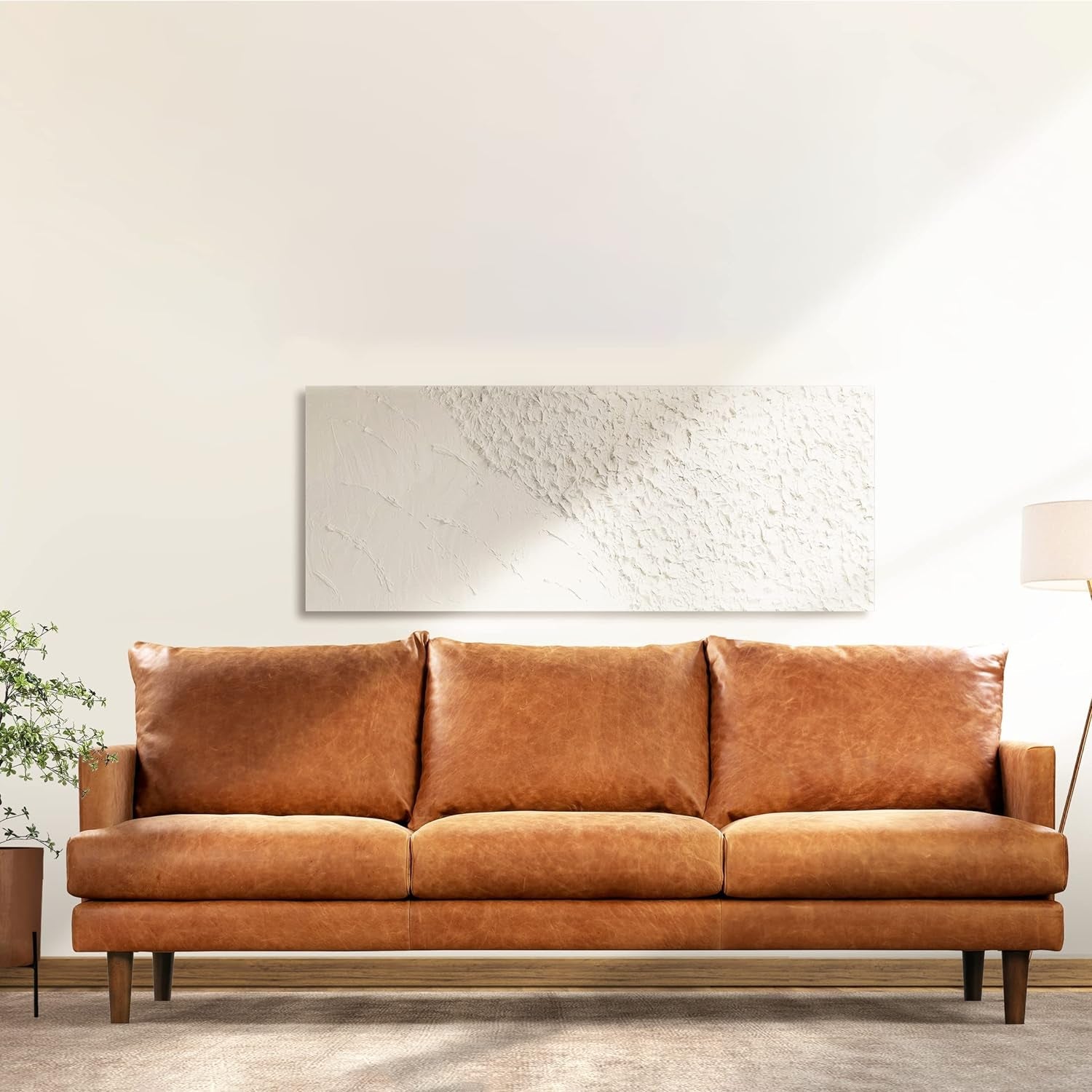 Brown sofa in a room with a light-colored wall and a lamp.