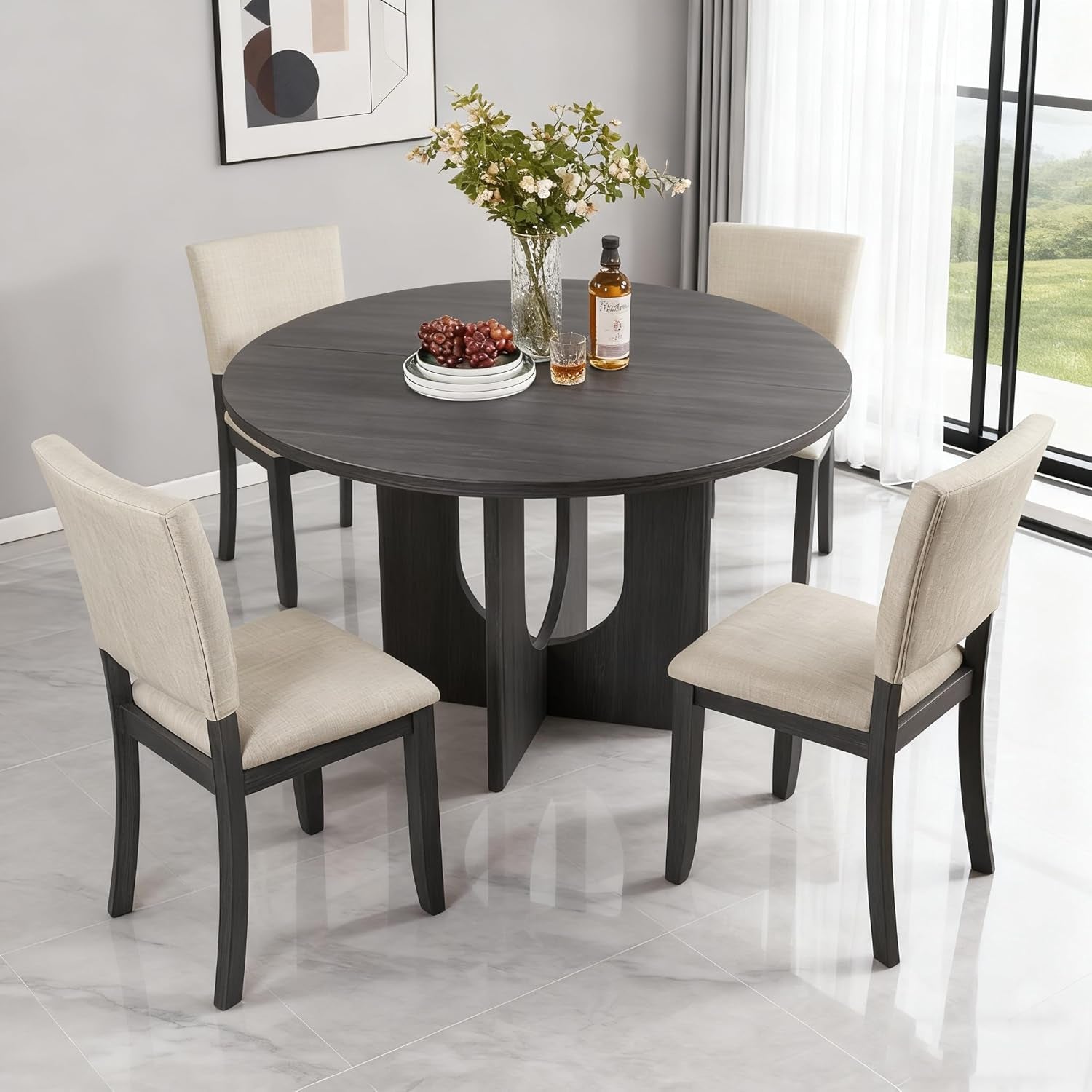 Dining room setup with a round dark wood table and four beige chairs.