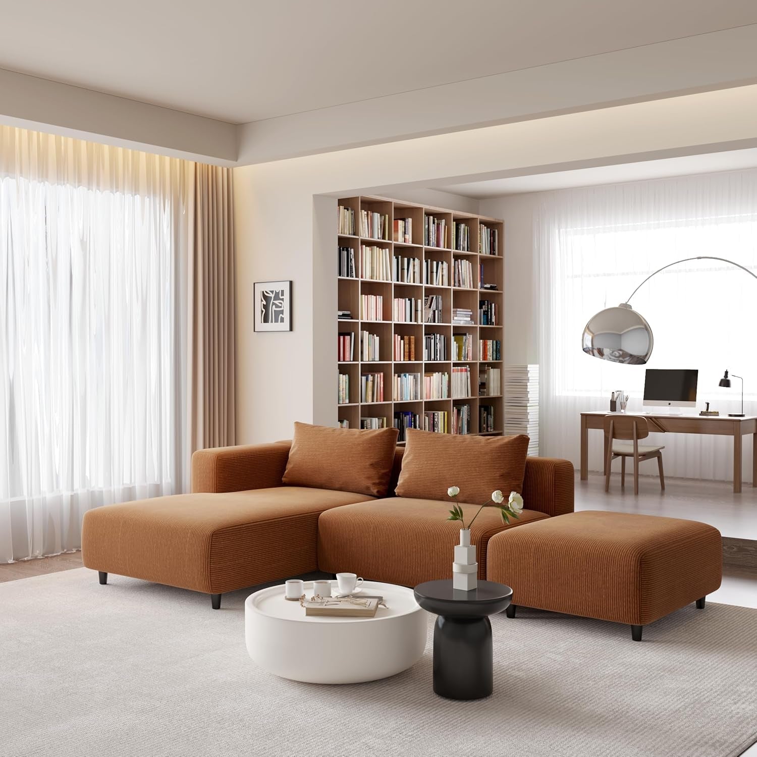 Modern living room with brown sectional sofa, white coffee table, and bookshelf.