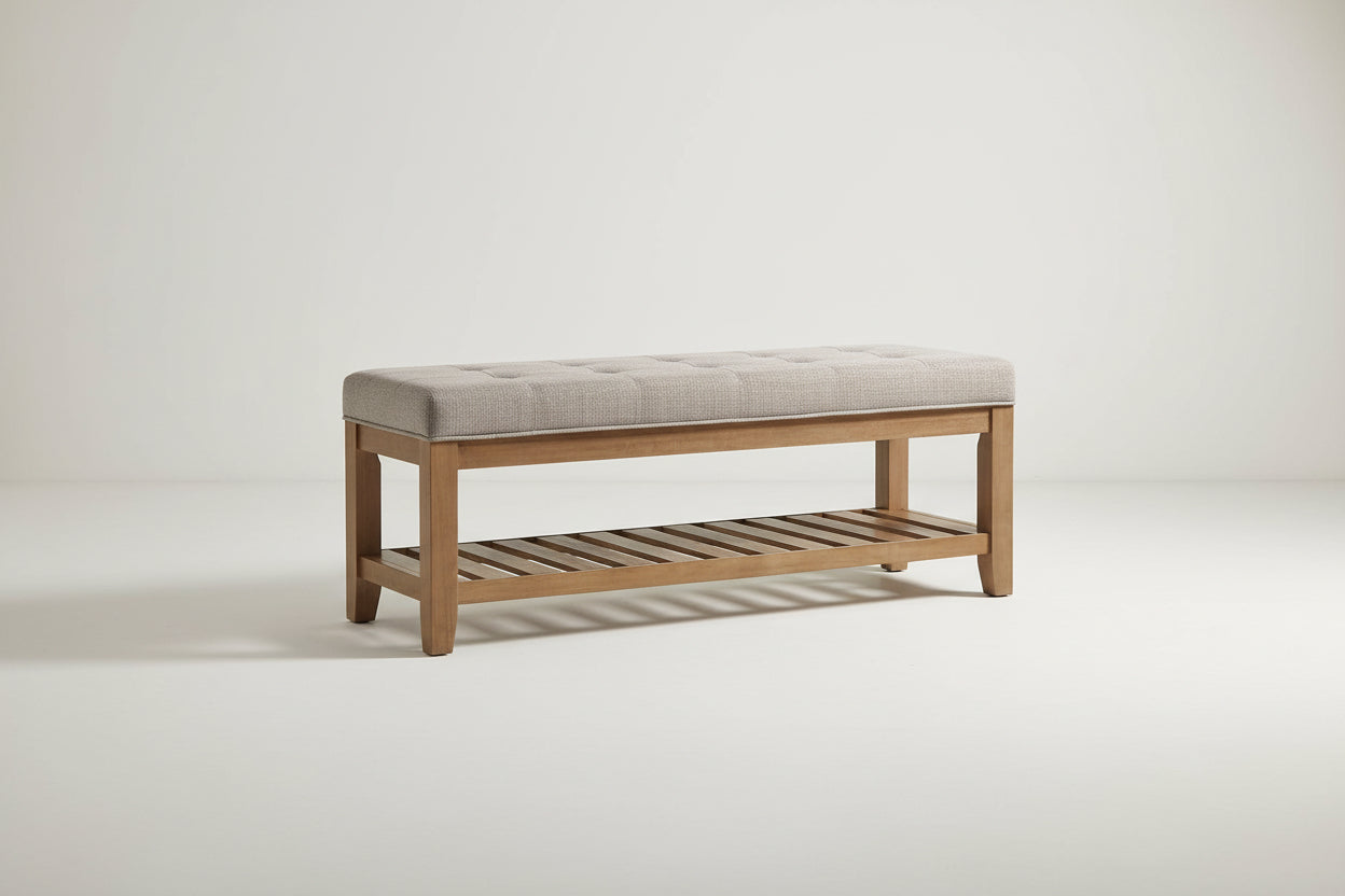 Wooden bench with a beige cushioned seat on a white background