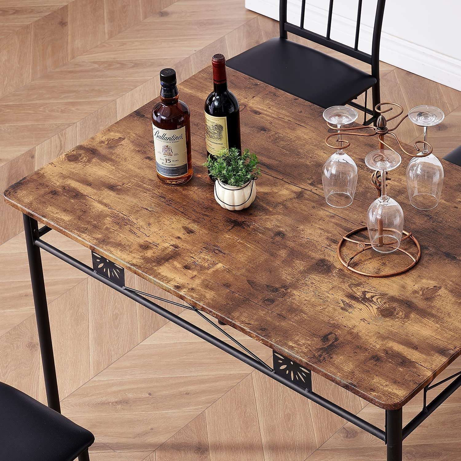 Wooden dining table with bottles and glasses on a wooden floor