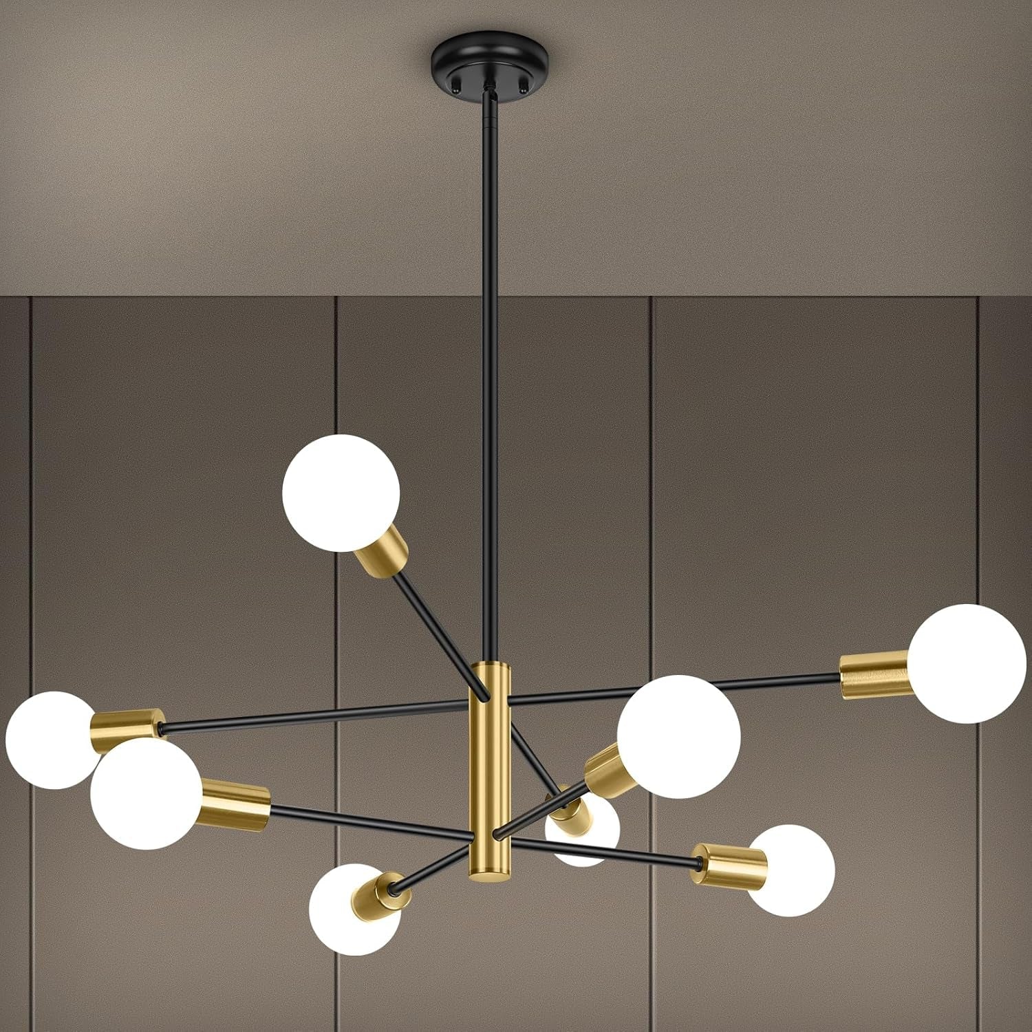 Modern chandelier with black and gold design on a neutral background