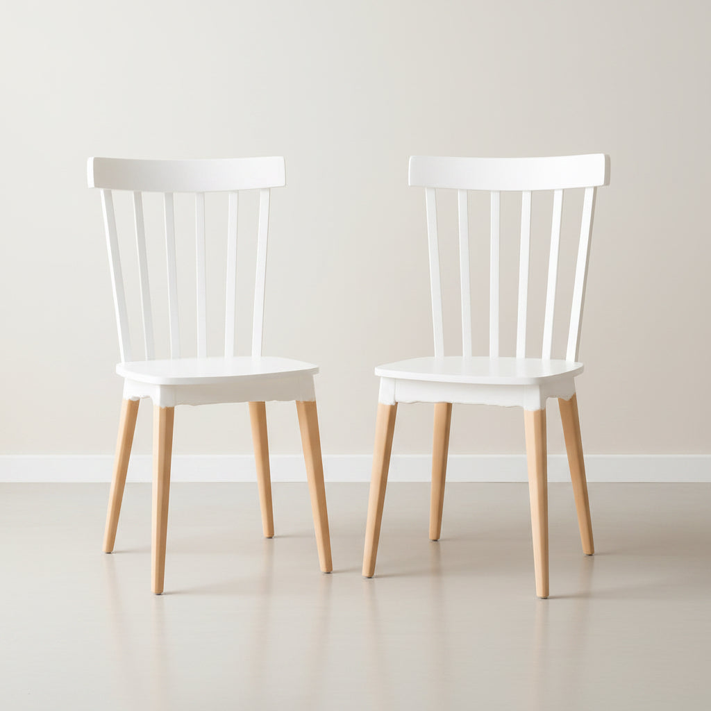 Two white wooden chairs in a room with a beige wall and rug.